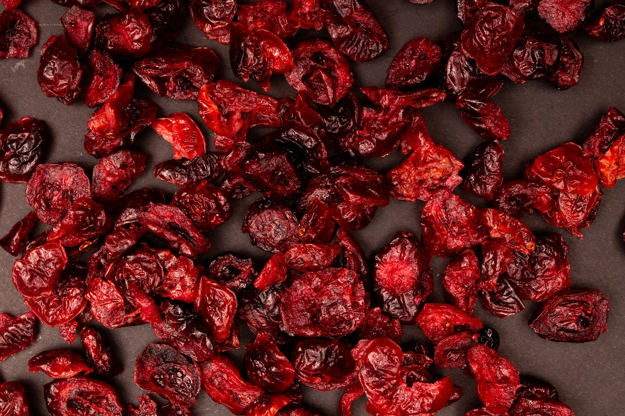 dried-cranberries-scattered-on-a-dark-surface.jpg Dried cranberries scattered on a dark surface